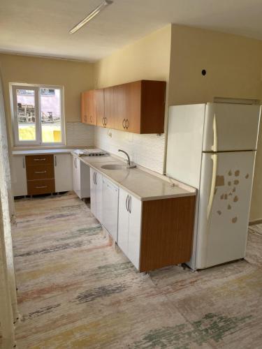 an empty kitchen with white appliances and a refrigerator at Ümit 2 Termal Apart Pansiyon in Pamukkale