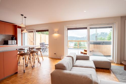 un salon et une cuisine avec un canapé et une table dans l'établissement Moho Mountain Home, les animaux fantastiques, à Gérardmer