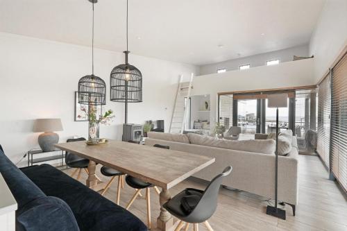 a living room with a table and a couch at Seaside Panorama Villa 6p - Direct aan de Baai - Villa 37 in Ouddorp