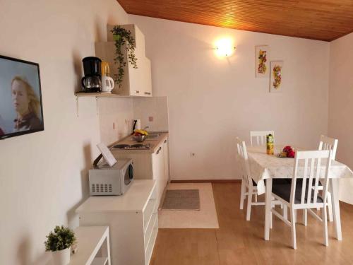 kuchnia i jadalnia ze stołem i kuchenką mikrofalową w obiekcie Apartment Valbandon, Istia 3 w mieście Fondole