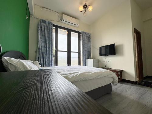 a bedroom with two beds and a television in it at 羅東夜市長虹 in Luodong