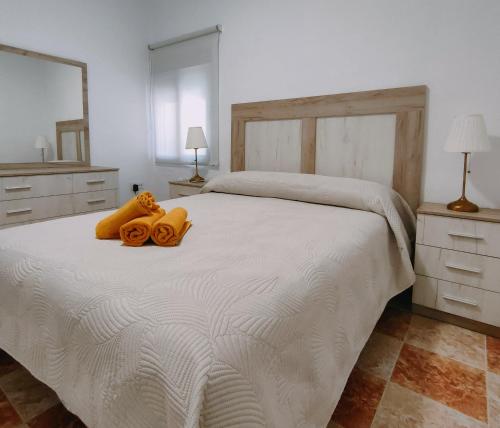 a bedroom with a white bed with two towels on it at Apartamento Playa Tanguillos del Mar in Cádiz