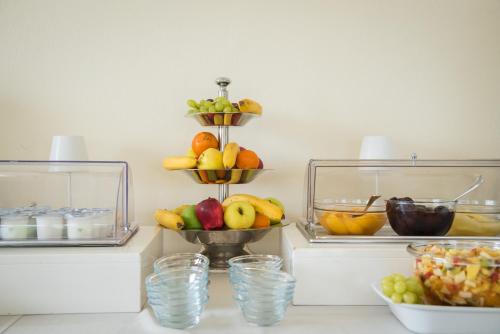a shelf with bowls of fruit and glasses of water at Hotel Porta Del Sole in Soiano del Lago