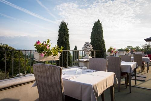a restaurant with tables and chairs on a balcony at Hotel Porta Del Sole in Soiano del Lago