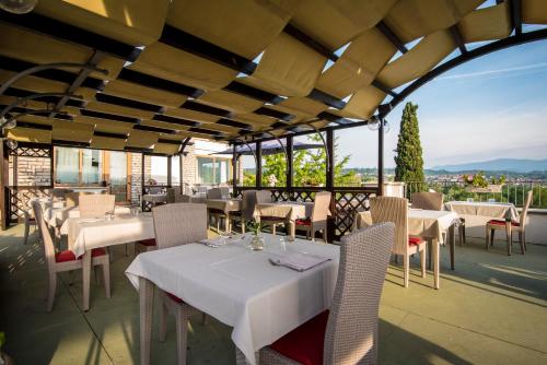 a restaurant with tables and chairs on a patio at Hotel Porta Del Sole in Soiano del Lago