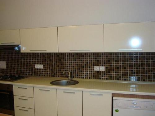 una cucina con mobili bianchi e un lavandino di Chamonix-Mont-Blanc a Chamonix-Mont-Blanc