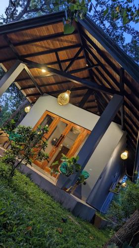a house with a glass door in the yard at Maritime Nest Cabanas in Tangalle