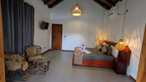 a bedroom with a bed and a table and chairs at Maritime Nest Cabanas in Tangalle