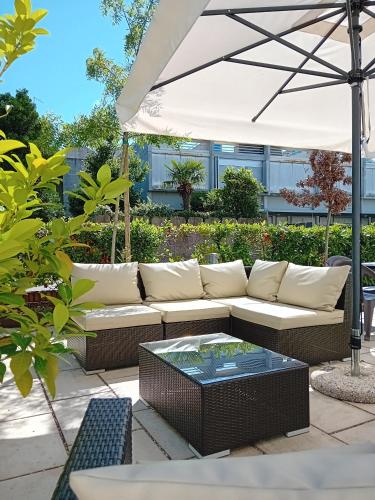 a white couch sitting under an umbrella on a patio at Boutique Hotel Nuovo Cason in Cavallino-Treporti