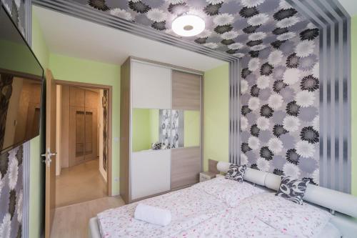 a bedroom with a bed and a wall with flowers at ★ BB Wellness Apartman ★ in Siófok