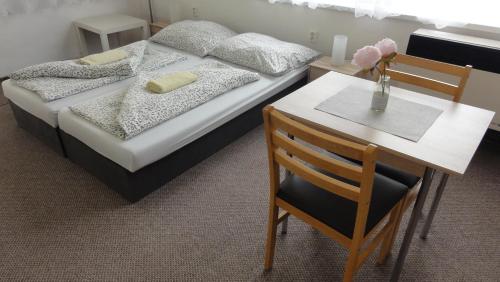 a bedroom with a bed and a table and a chair at Penzion U Hradeb in Znojmo