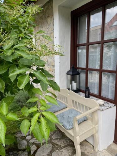 a bench sitting on a porch next to a window at Nemespécsely Udvarház in Pécsely