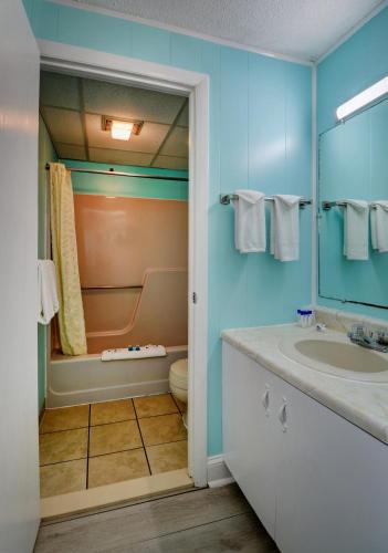 a bathroom with a sink and a toilet and a mirror at Majestic Regency Resort in Wells