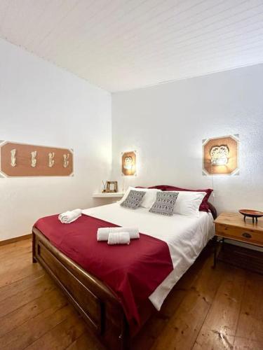 a bedroom with a large bed with a red blanket at NURAS - Gioberti Charme House in Alghero