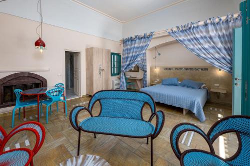 a bedroom with a bed and chairs and a fireplace at Passion Blue Villas in Oia