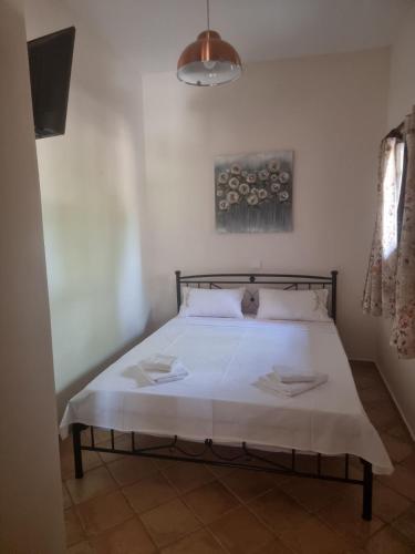 a bedroom with a bed with white sheets and pillows at Studio Καρπώ Karpo in Galaxidhion