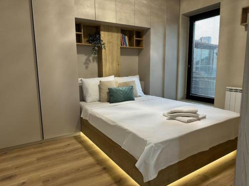 Un dormitorio con una cama con sábanas blancas y una ventana. en Modern Vitosha Maisonette with Garage, en Sofía