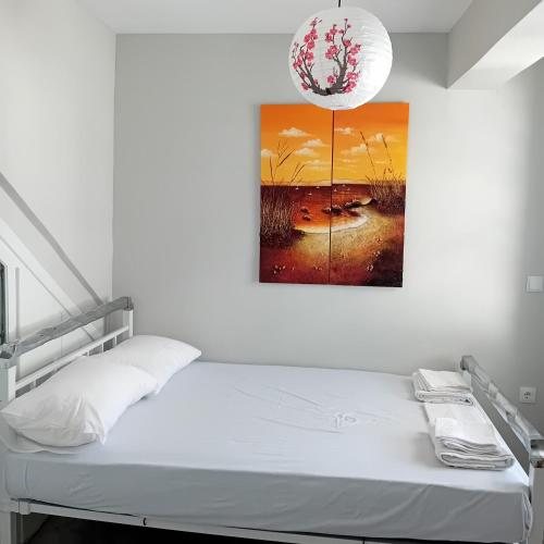 a bedroom with a bed and a painting on the wall at Apartments in Amarynthos - Evoia in Amarynthos