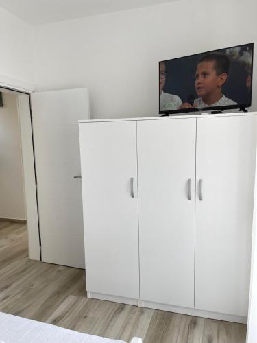 two white cabinets with a tv on top of them at Relax Apartmani in Sutomore