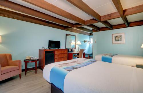 a hotel room with two beds and a chair at Majestic Regency Resort in Wells