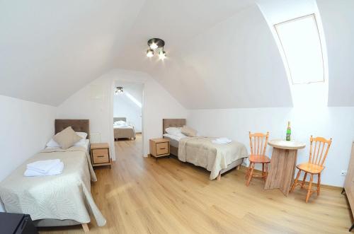 a bedroom with two beds and a table and chairs at Przystań Admiralska 11 in Jarosławiec
