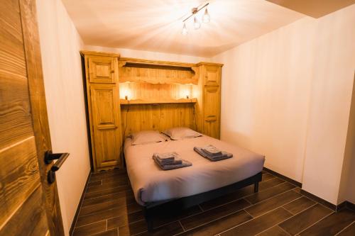 a small bedroom with a bed with a wooden headboard at Moho Mountain Home in Gérardmer