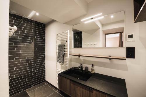 a bathroom with a black sink and a mirror at Moho Mountain Home in Gérardmer
