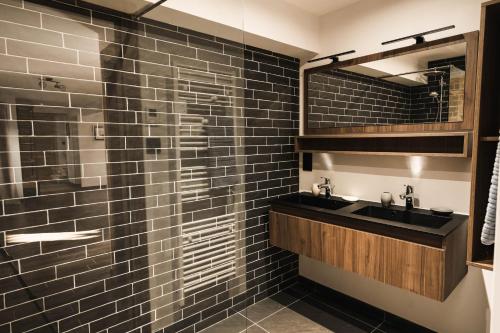 a bathroom with two sinks and a glass shower at Moho Mountain Home in Gérardmer