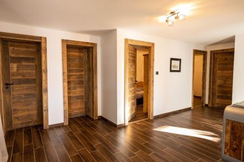 an empty room with wooden doors and wooden floors at Moho Mountain Home in Gérardmer