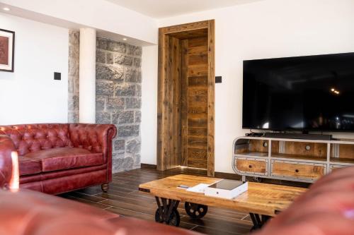 a living room with a couch and a flat screen tv at Moho Mountain Home in Gérardmer