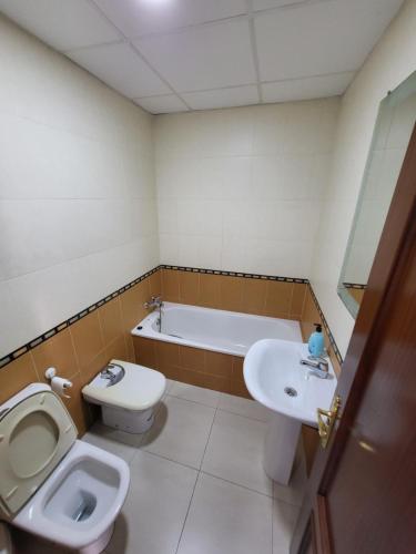 a bathroom with a toilet a sink and a bath tub at Casa Andrea in Puerto Real