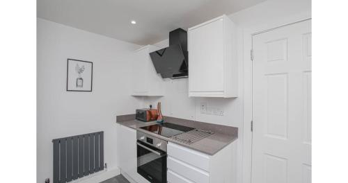a kitchen with white cabinets and a counter top at Jerichos Rest in Oxford