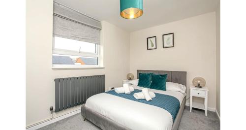 a bedroom with a bed with green and white pillows at Jerichos Rest in Oxford