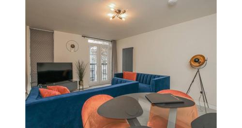 a living room with a blue couch and a tv at Jerichos Rest in Oxford