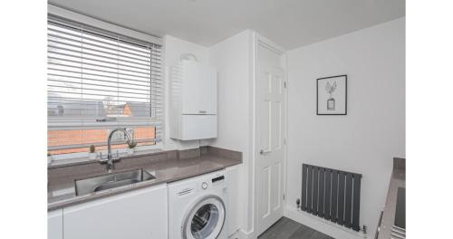 a white kitchen with a sink and a washing machine at Jerichos Rest in Oxford