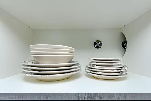 two stacks of plates sitting on a shelf at 7th Avenue - Apartamentos UROOMS in Curitiba