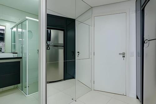 a glass shower with a door in a bathroom at 7th Avenue - Apartamentos UROOMS in Curitiba