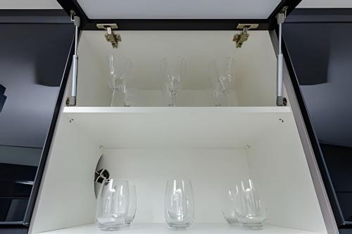 a display case with wine glasses on it at 7th Avenue - Apartamentos UROOMS in Curitiba