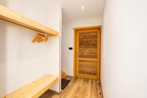 a room with a wooden door and a wooden bench at Moho Mountain Home in Gérardmer