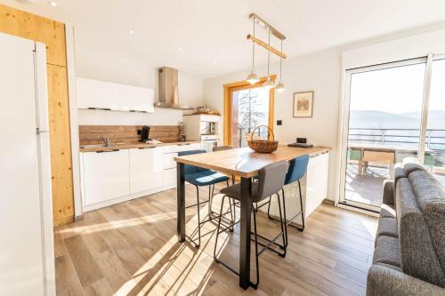 a kitchen and dining room with a table and chairs at Moho Mountain Home in Gérardmer