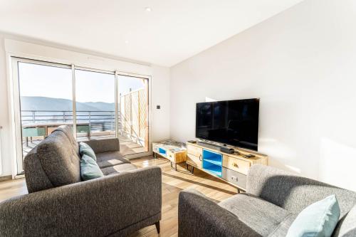 a living room with two couches and a flat screen tv at Moho Mountain Home in Gérardmer