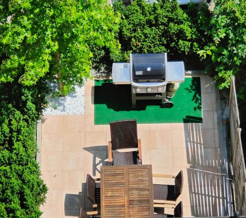 een bovenaanzicht van een grill met stoelen en bomen bij Eleonoras Ferienwohnung in Würzburg Stadt mit Terrasse und eigenen Parkplätzen vor der Tür, für große Gruppen bis zu 13 Personen geeignet in Würzburg