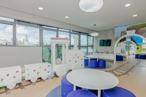 a childrens play area with tables and chairs at 7th Avenue - Apartamentos UROOMS in Curitiba