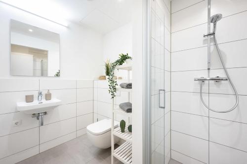 une salle de bain blanche avec douche et toilettes dans l'établissement Urban Apartment with 2 Bedrooms, à Munich