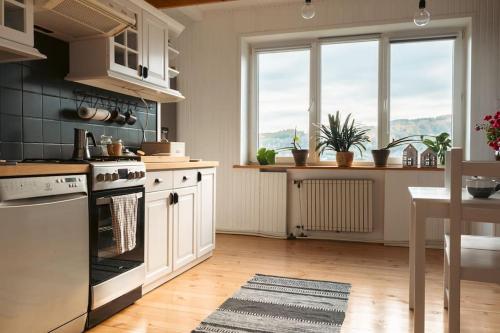 una cocina con electrodomésticos blancos, ventanas y una mesa. en Za Oknem Wierchowa, en Rymanów-Zdrój