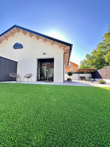 una casa con un prato verde davanti di Ensueño a Molinaseca