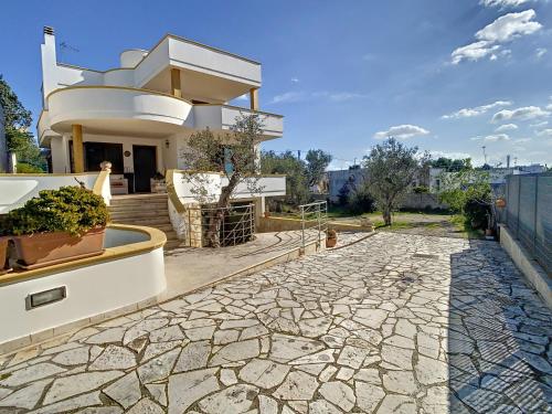 a house with a stone walkway in front of it at Terra Bianca Salento in Nardò
