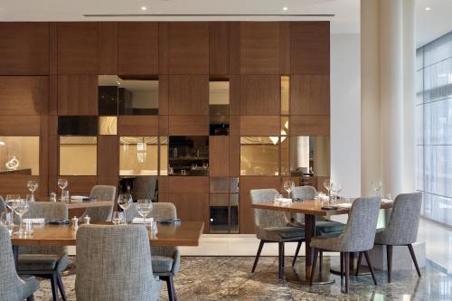 a dining room with wooden tables and chairs at Meliá Desert Palm Member of Meliá Collection in Dubai