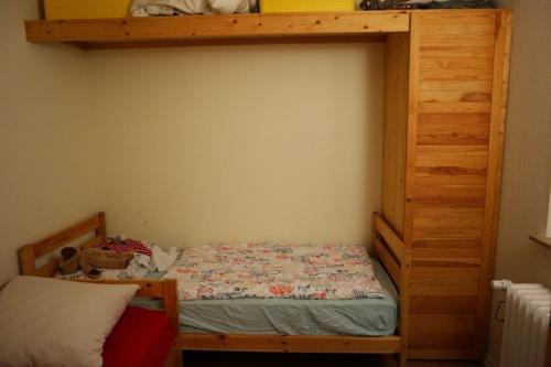 1 Schlafzimmer mit einem Etagenbett aus Holz und einem großen Bett in der Unterkunft Ferienhaus Ostfriesland im Teichweg in Berumbur