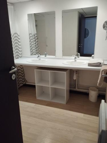 une salle de bain avec deux lavabos et un grand miroir dans l'établissement Lourdes grand studio classé 2 étoiles de 1 à 4 personnes, à Lourdes